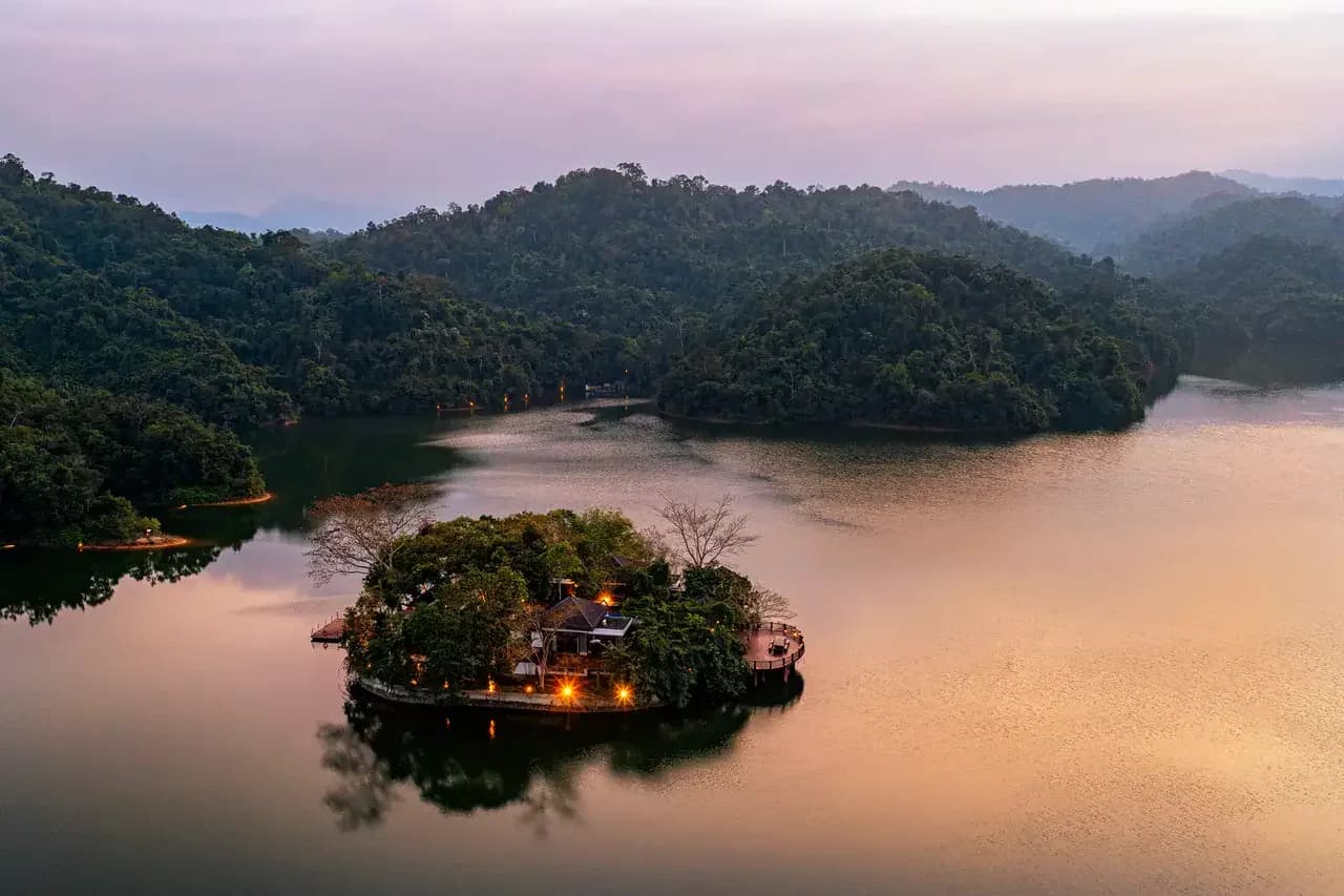 夕阳映照下的湖中小岛与海南山地雨林